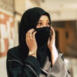 Muslim niqab woman Arab saudi girl closeup close face with black chador.